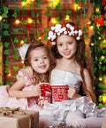 Two children with mugs in front of fake ivy vines with 80 LED string lights, cozy indoor setting, decorative background.