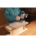 Man using a router with the Straight Shooting Three In One Handle Router Template For Smooth Cutting Boards And Killer Charcuterie Sets With Zero Headache Goblet Or Curved Handles Crafted From Heavy Duty Clear Acrylic Shaping Jig.