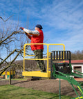 Forklift safety cage, 36x36 inches, yellow, on a green forklift; worker pruning a tree from elevated basket.