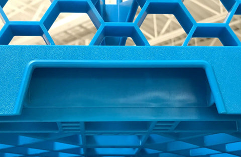Close-up of blue polypropylene OptiClean NeWave 20-compartment glass rack with hexagonal design and two extenders.
