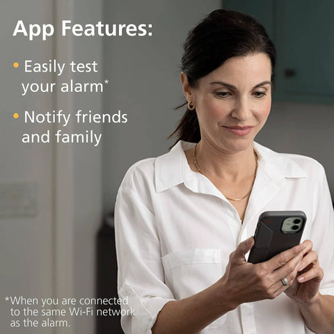 Woman using phone with app features of Smart Carbon Monoxide Detector And Indoor Air Quality Monitor 2 In 1 Plug In displayed