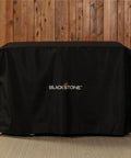 Heavy Duty 28 Inch Griddle Cover With Hood For Flat Top Gas Grills Water And Weather Resistant 600D Polyester With Cinch Straps For Secure Fit And Full Coverage on a wooden patio
