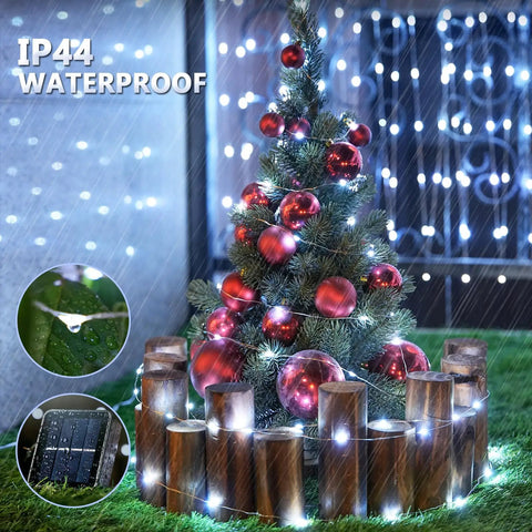 Two Pack Of 33 Feet Solar String Lights With 100 LEDs Each illuminating a Christmas tree outdoors in rain, IP44 waterproof.