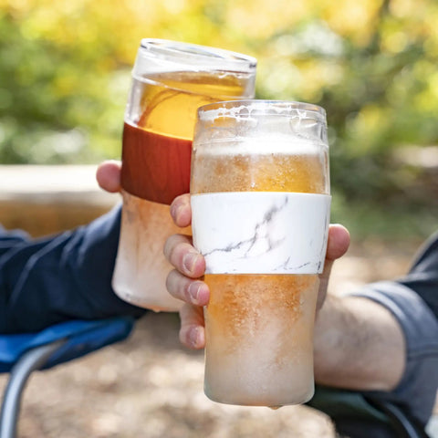 Level Up Your Chill Game With These Freezable Pint Glasses Double Walled Insulated Tumblers That Keep Beer And Iced Coffee Straight Frosty Built To Last Set Of Two Wooden Handles held outdoors with drinks