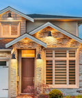 Two Pack Outdoor Wall Sconces With Hammered Metal Shade And Gold Interior illuminating modern house exterior in evening