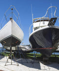 Two boats on stands in a marina, showcasing areas ideal for Dockside Ready Marine Grade Lubricant And Penetrating Oil For Boats And Gear.