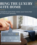 Hand holding white tea scented whole home air freshener system for HVAC filters, bedroom setting in background.