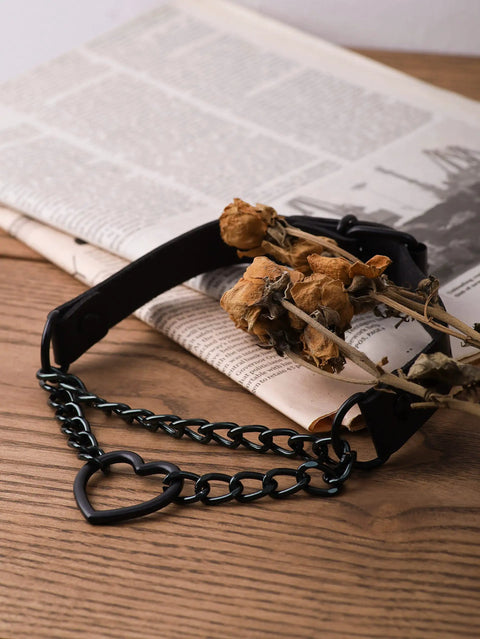 Dope Gothic Punk Leather Choker Necklace Featuring Adjustable Black Heart Chain For Edgy Grunge Emo Style And Alt Streetwear Vibes laid on wooden surface with dried flowers.