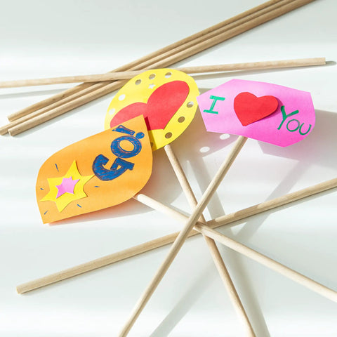 Premium Unfinished Hardwood Dowel Rods 1/4 X 12 Inches Ten Pack holding colorful paper signs for DIY crafts.