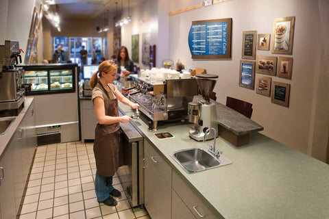 Barista using a Commercial Bar And Pantry Faucet 2.2 GPM Chrome Finish With M-Dura Cartridge in a busy kitchen setting