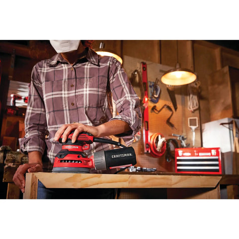 Person using Beast 5 Inch Orbital Sander With 12000 OPM, 3 Amp Corded Hand Sander in workshop with wooden surface.