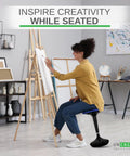 Person using Flexible Standing Desk Stool for Ergonomic Active Sitting in a creative studio setting to reduce leg fatigue.