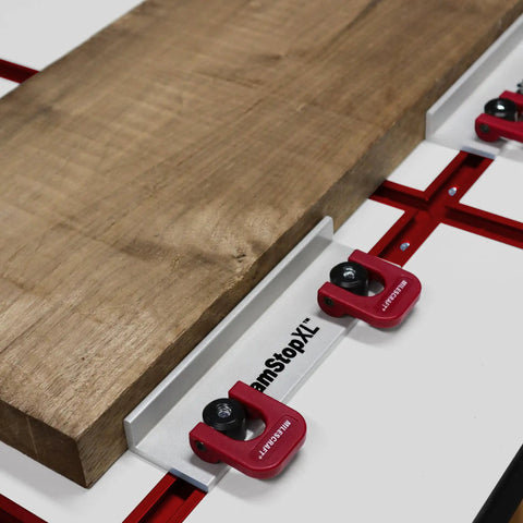 Dead Simple Quick Swap Cam Stops For Router Tables With Tight Grip T Track Clamps Low Profile Anodized Aluminum Body Fits Most Workbenches And Jig Systems 2 Pack Shop Essential positioned on a workbench with wood slab.