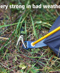 Heavy Duty Aluminum Tent Stakes 20 Pack 7 Inch Ground Stakes With Hooks securing a tent in grassy terrain