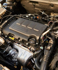 Detailed view of a car engine showcasing various components, tubes, and connectors in an engine bay.