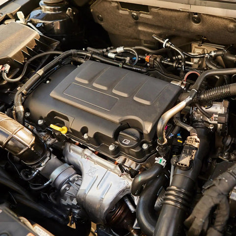 Detailed view of a car engine showcasing various components, tubes, and connectors in an engine bay.