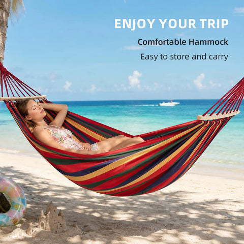 Person relaxing on Two Person Portable Camping Hammock Bed With Anti Roll Balance Beam And Tree Straps at a beach
