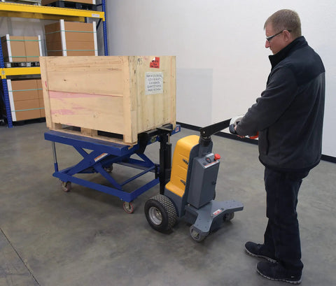 Heavy Duty Electric Powered Tugger With 1000 Lb Pull Capacity For Effortless Factory Material Handling featuring ergonomic handle moving a wooden crate.