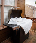 Emergency Fire Blanket 40 By 40 Inches, Woven Fiberglass Fire Shield, covering a grill on a wooden deck for fire suppression.