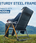Side view of a person seated on an oversized folding rocking camping chair with padded high back, supporting up to 400 lbs, by a lake