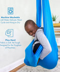 Child in blue sensory swing for kids and adults that feels like a big hug, indoor and outdoor safe, holds up to 300lbs, soft stretch nylon