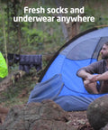 Pocket Friendly Travel Laundry Sack With A Built In Washboard Surface For Quickly Scrubbing Down Socks And Undies While Backpacking Or Hitting The Road Without Lugging Heavy Machines Or Clunky Gear hanging outside a tent.