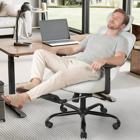 Person relaxing in an ergonomic office chair with footrest and mesh back, adjustable headrest and armrests, gray, in home office