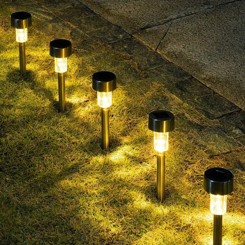 Sun Powered Solar Pathway Lights Outdoor Waterproof Stainless Steel LED Garden Lights illuminating a yard path at night.