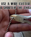 Hands cutting 24 Inch Ball Chain Necklace In T304 Stainless Steel Two Point Four Millimeter Gauge Made In The USA with wire cutter