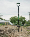 Rugged Heavy Duty Digging Fork With Carbon Steel Head And Fiberglass Core in garden, showing short handle and no-slip H-Grip.