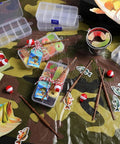 Gone Fishing Party Favors Kit with tackle boxes, mini fishing rods, red white floats, cards, and rope decor on a camo background.