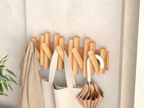 Foldable Wall Coat Rack With Five Hidden Hooks displaying coats, bags, and an umbrella, modern pine wall mount hanger in use