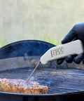 Instant Read Thermapen Inspired Digital Food Thermometer In Cayenne Red measuring steak on grill
