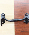 Two Pack Hook And Eye Latch Set Heavy Duty Stainless Steel Gate Latch Lock For Sliding Barn Doors Windows Shutters Garage Fence Closet And Shed Doors With Screws 4 Inch Black installed on a two-tone wood surface