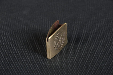 Dope Brass Habaki Collar Clip For Katana And Japanese Swords angled view on textured surface