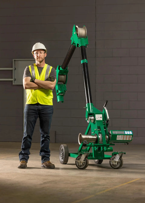 Greenlee 10k Tugger Package Featuring Dual Speed Motor For Faster Pulls, worker with mobile VersiBoom tow rig gear on job site.
