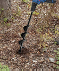 Person using garden auger drill bit for bulbs and bedding plants, 1.8 by 15 inch, in garden soil with a blue drill