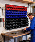 Wall Mounted Garage Storage Bin Kit 94 Piece Organization System with labeled bins on wall above workbench in use.