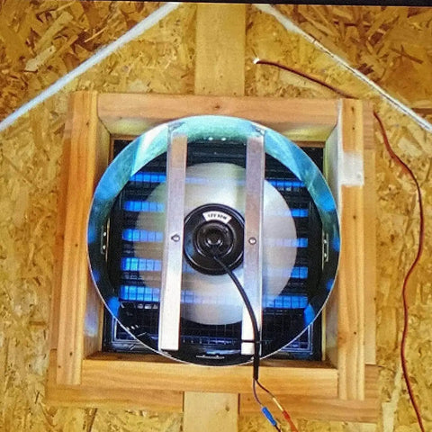 Solar Attic Fan 12 Inch 50W With Thermostat Made In USA installed in wooden gable vent with visible wires