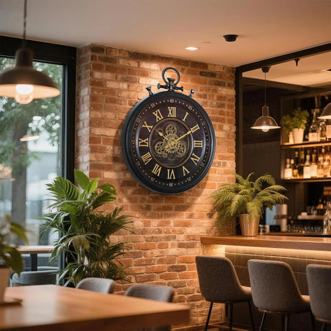 24 Inch Moving Gear Wall Clock Oversized Industrial Steampunk Decor With Big Numerals Carbon Black Finish mounted on a brick wall.