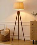Tall Tripod Floor Lamp With Wood Legs And Cream Drum Shade, Modern Mid Century Style LED Lamp For Living Rooms, Bedrooms, And Home Offices, Walnut Brown Finish For A Cozy Reading Light Vibe in a living room setting.