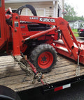 Ratcheting Chain Binder Three Eighths To One Half Inch Four Pack Load Binders securing orange farming equipment on trailer.