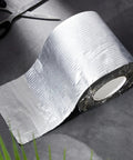 Six Inches By Thirty Three Feet Peel And Stick Roofing Roll With Strong Bond Rubber Adhesive and Sun Shield Aluminum Top view on a dark surface.