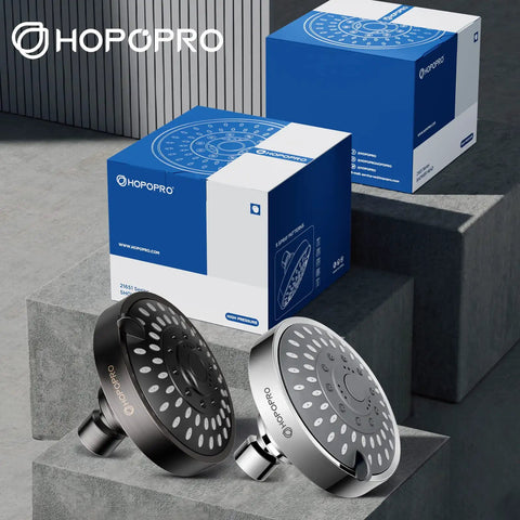 Five Mode High Pressure Shower Head With High Flow 4 Inch Oil Rubbed Bronze Finish alongside blue packaging on stone blocks