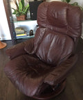 Brown leather recliner chair positioned on wooden floor with soft cushions and supportive back for comfort and relaxation.