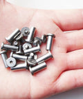 Hand holding stainless steel folding knife bracket bolts and lock shaft rivets for DIY knifemaking pivot pins, EDC screw fasteners.