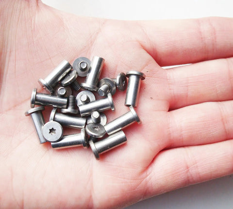 Hand holding stainless steel folding knife bracket bolts and lock shaft rivets for DIY knifemaking pivot pins, EDC screw fasteners.