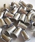 Close-up of 25 Piece M10 Aluminum Rivet Nuts Flat Head Rivnut Inserts Set With M10x1.5 Threads, 10mm Body, Ribbed Design For Higher Torque