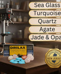 Front view of Drilax 30-Piece Diamond Drill Bit Set with 1/8 in shank; DRILAX case on a workbench with sea glass nearby