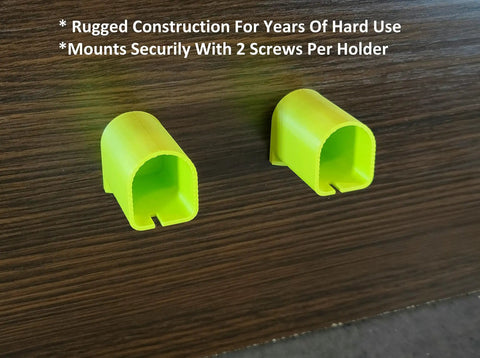 Two bright green battery mounts from 18V Cordless Tool And Battery Mounts Set 12 Pack attached to a wooden surface